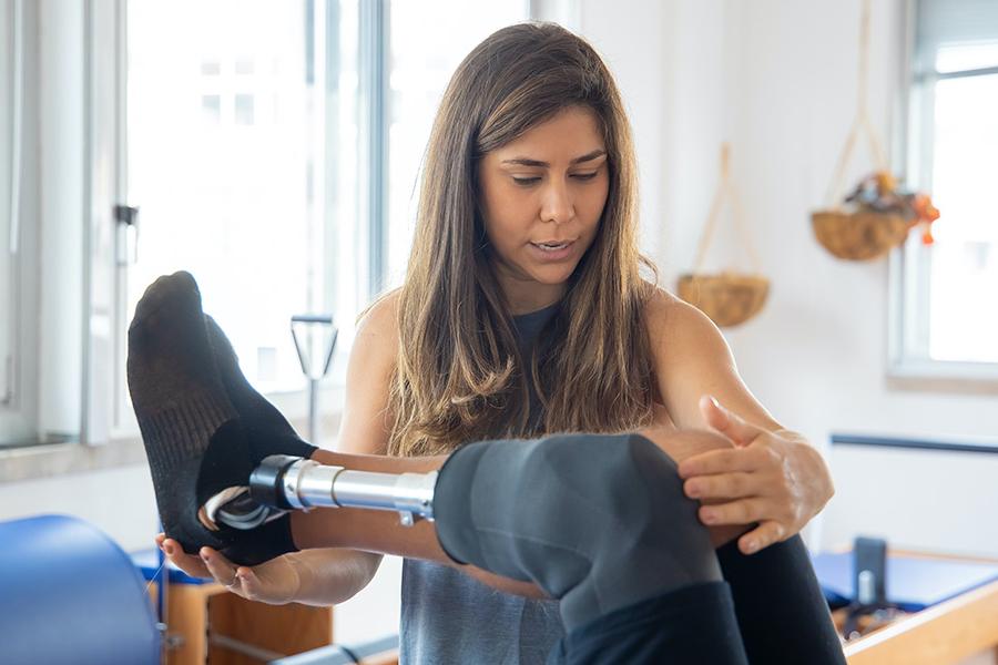 A person helps someone with a prosthetic leg.