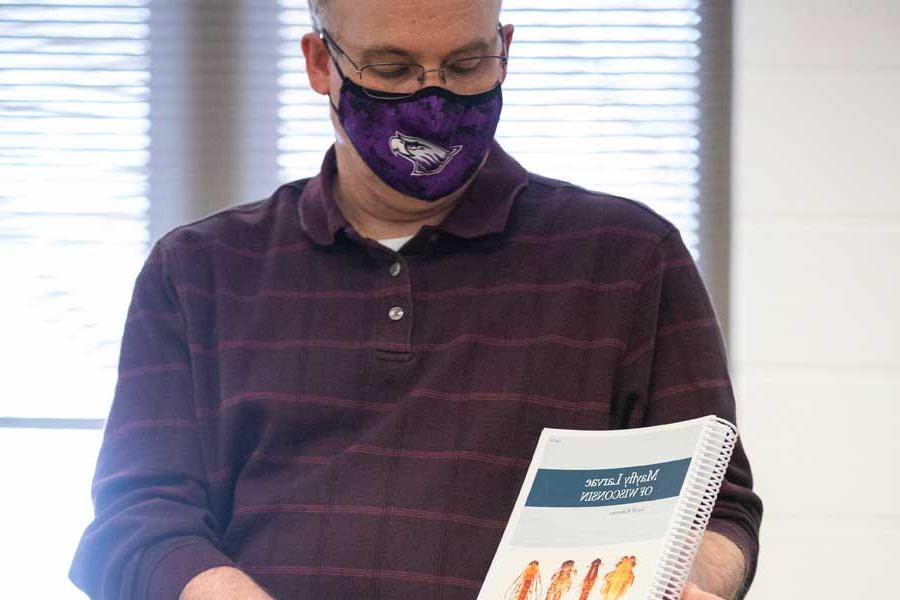 Tom Klubertanz holds an illustrated book on mayflies.