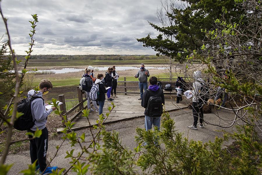 Students stand outside watching a stormy sky.