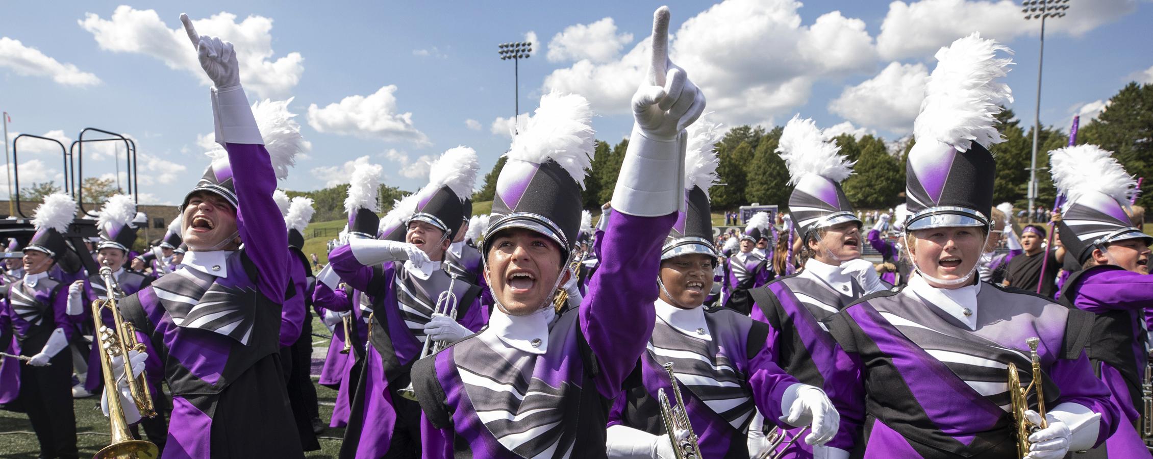 The Warhawk Marching Band cheers on the football field.